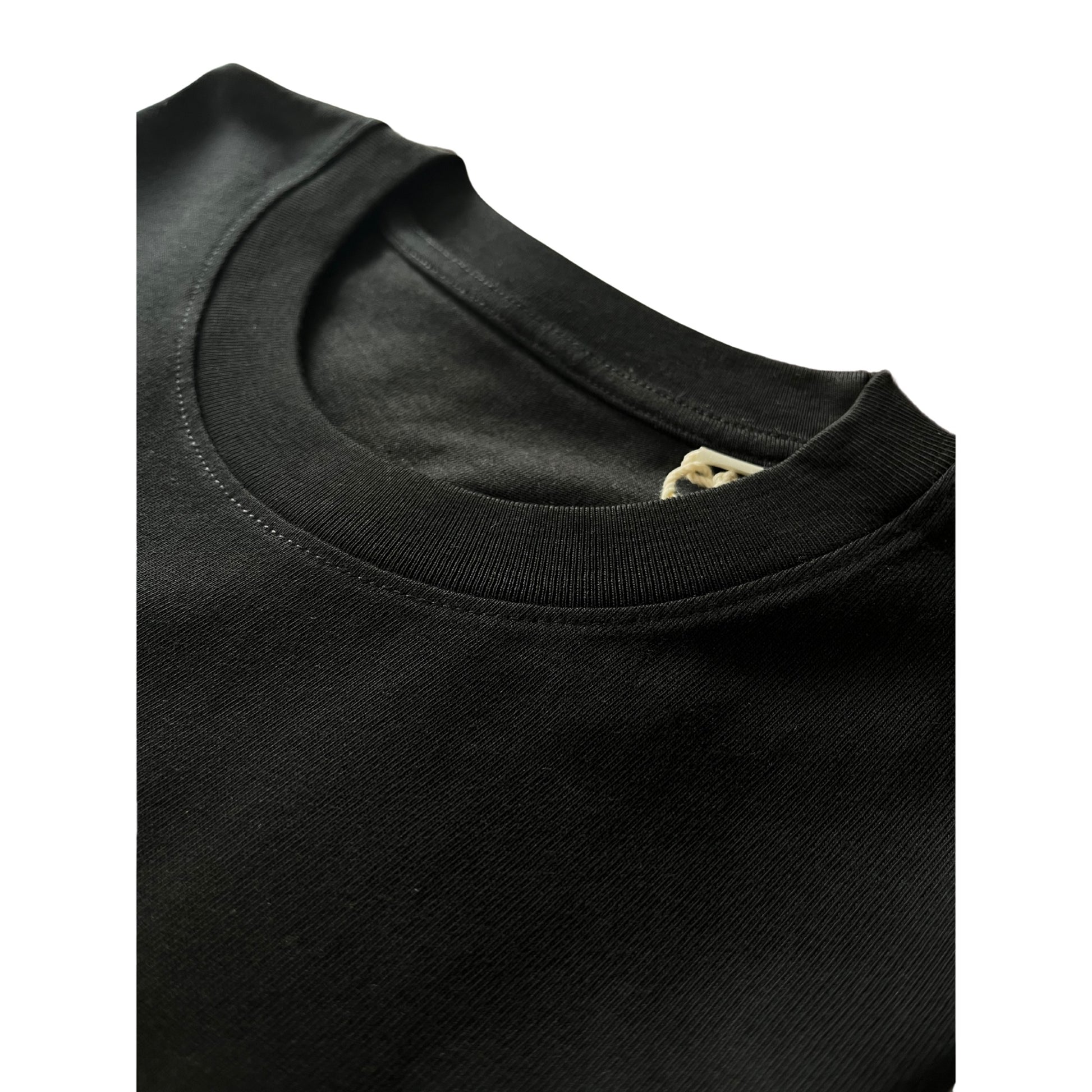 Close-up of neckline stitching on Suutoo black organic cotton T-shirt by Kimaa, showcasing quality craftsmanship